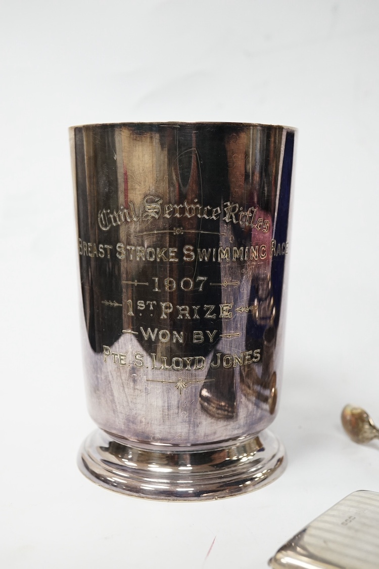 A George V silver mounted brass cased travelling timepiece, London, 1916, 70mm, together with a silver napkin ring, a pair of silver sugar tongs, a cased set of silver Victorian silver teaspoons with sugar tongs and a pl